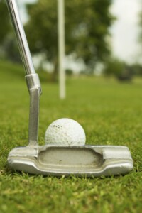A person lays a putt and practices golf mindfulness.