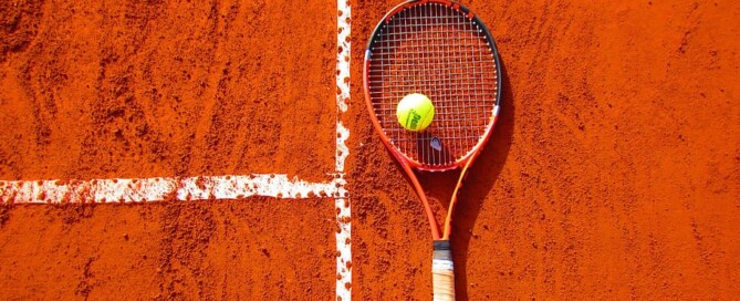 Setting tennis goals; a racket lies on a clay court.